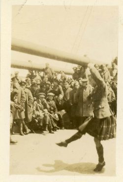 Kilted dancer entertaining mixed group of 15th Bn and other troops on board RMS Baltic 1919. Transporting the 15th Bn from the UK to Canada.