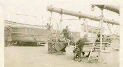 Officers relaxing on board RMS Baltic. Seated centre is Lt Smith a 2nd Ypres POW. Kneeling right is Lt JE Banton ?. Seated left is Maj Mackenzie (MO)? Standing is ?
