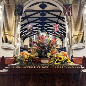 Communion Table in St Andrew's Church from the rear showing the Regiments Colours that have been retired hanging in the chancel.
